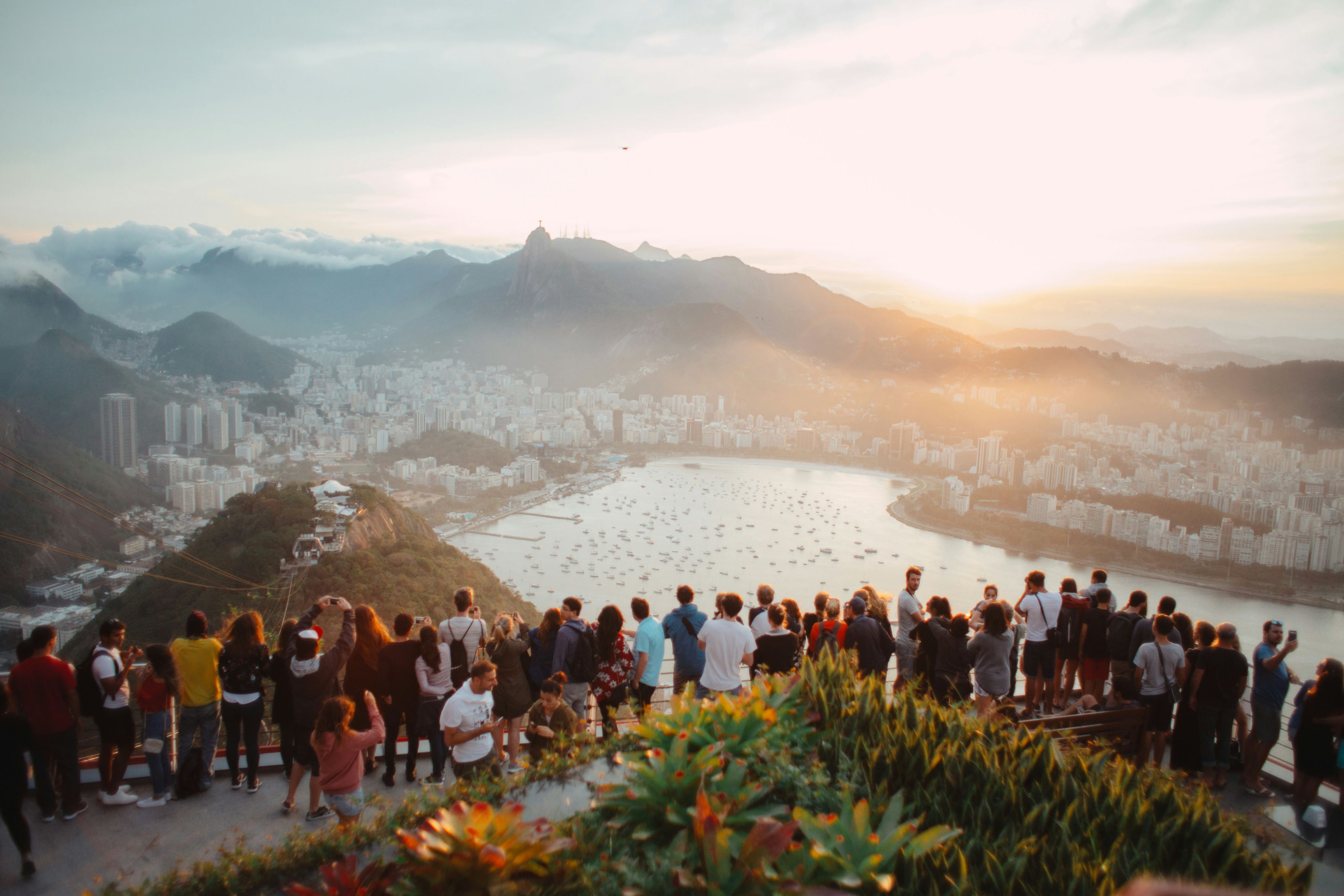 group of people standing facing lake view